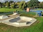 in ground paddling pool and skatepark located centrally in the park's grassed area.