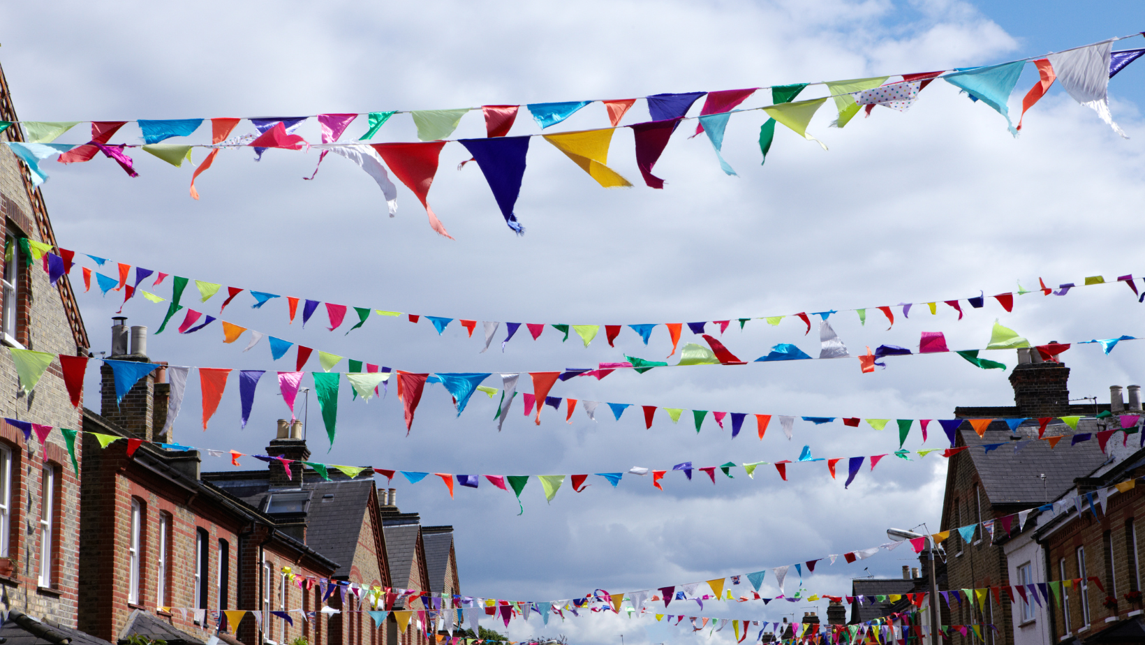 multi-coloured triangular bunting hanging across the street from house to house