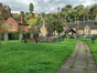 Small area of open green space with benches and footpath running through the centre. Surrounded by old Georgian houses, church and buildings