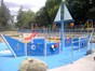 view of splashpad which has painted mid-blue boat in the centre