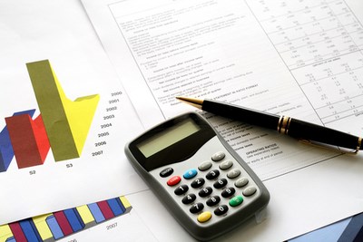 a calculator and pen on desk with accounting documents