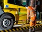 Man bent down at side of refuse lorry