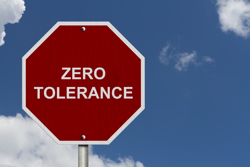 Sign which says zero tolerance with blue sky and clouds in background