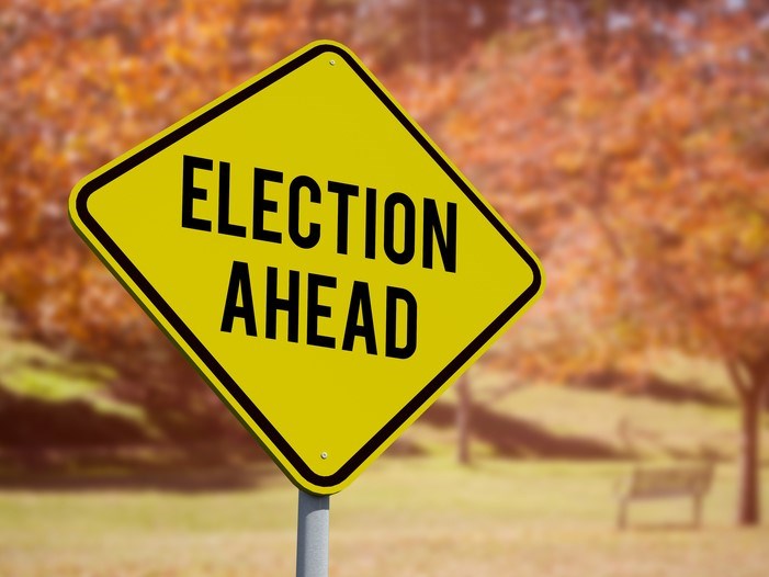 Election ahead sign in front of autumn trees