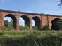local nature reserve with a viaduct running alonside with a railway line above.
