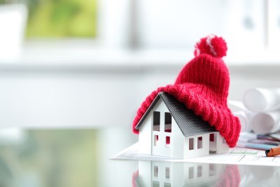 Model house with a red bobble hat on top 