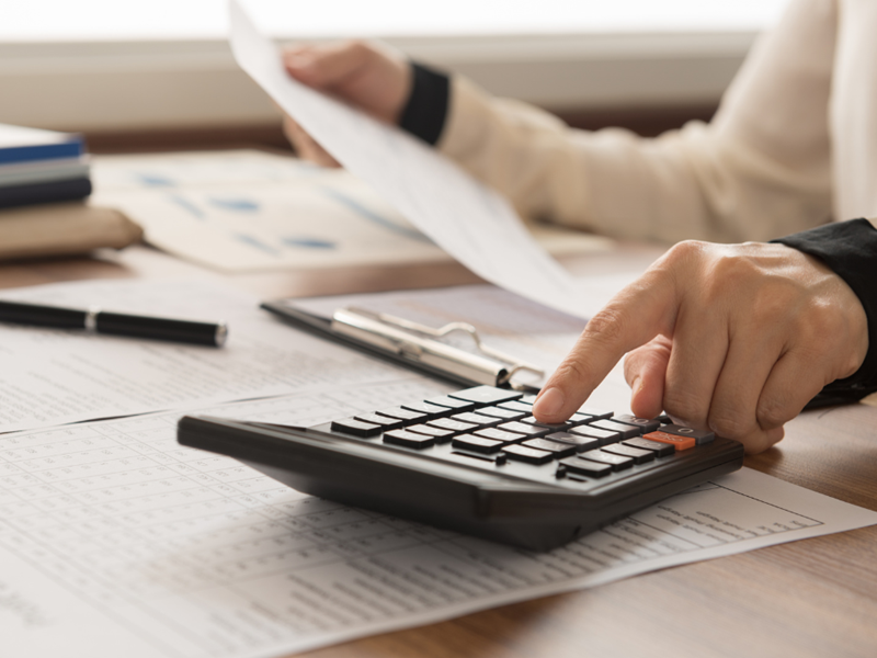 A person at a desk using a calculator