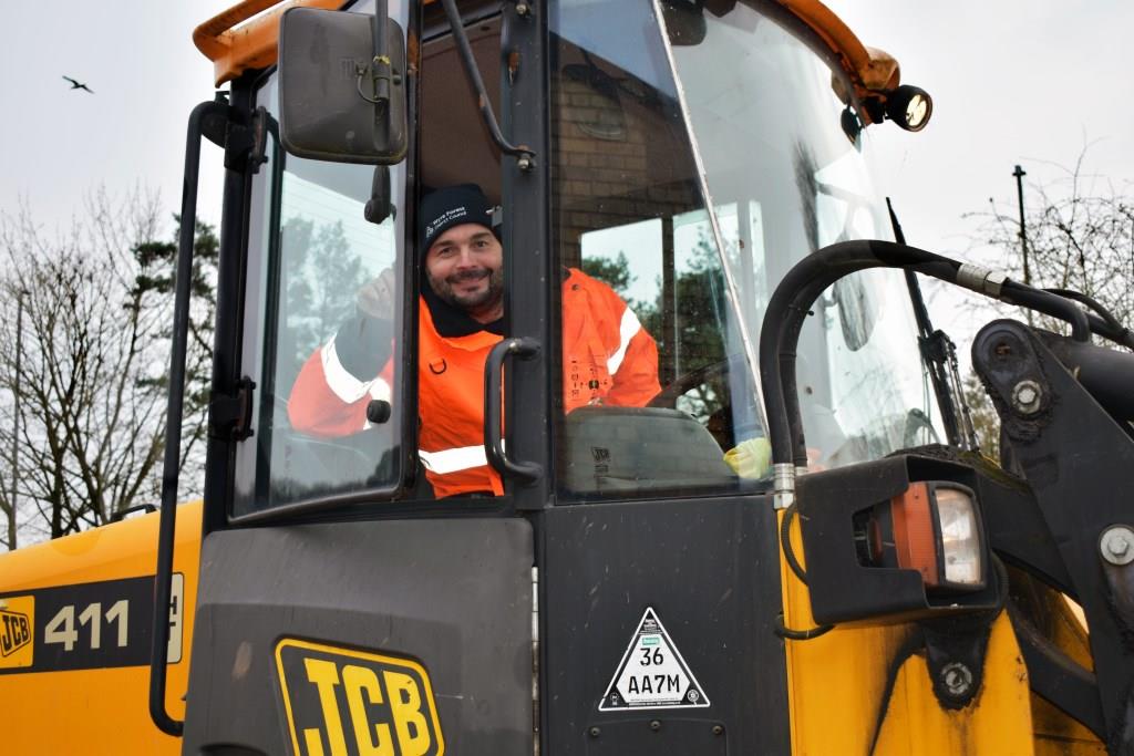 man in high vis sitting in cab of JCB