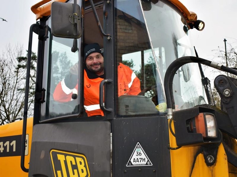 man in high vis sitting in cab of JCB