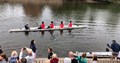 Four people dressed up as Queen's guard and rowing