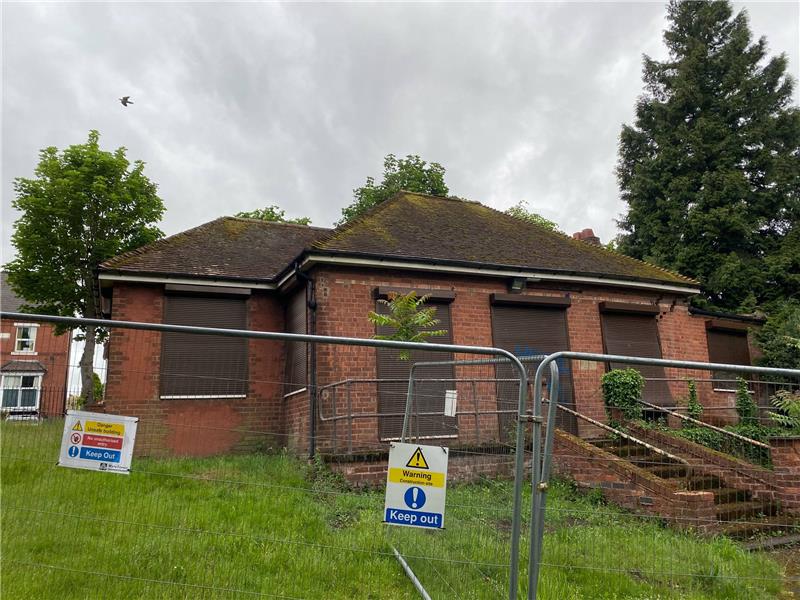 Red brick building with fencing around it
