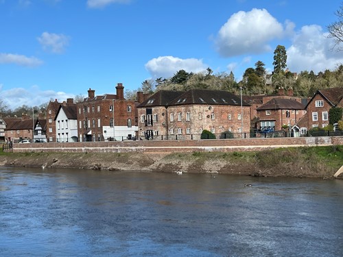 row of brick and white buildings on riverbank
