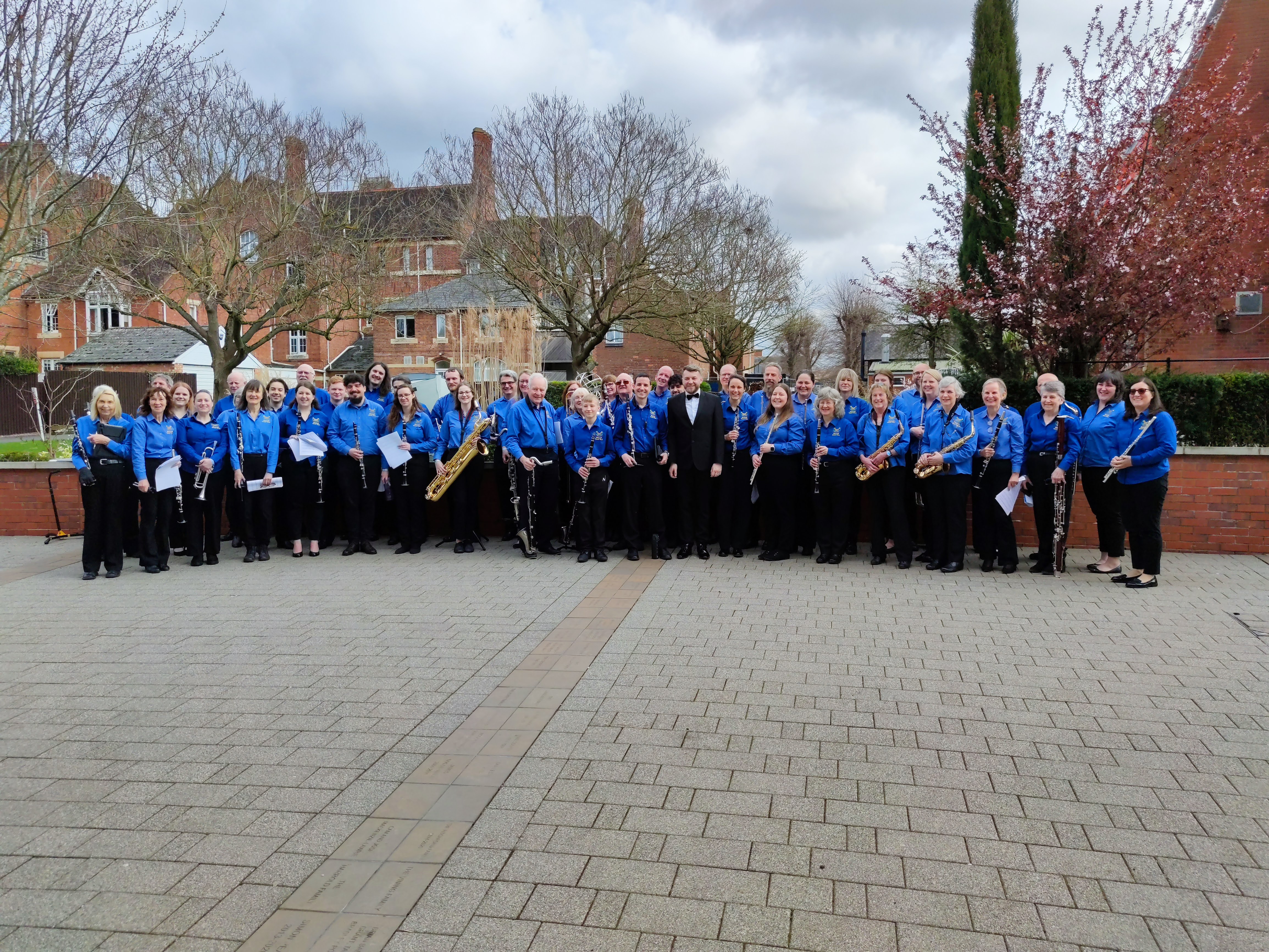 Members of the Blackwell Concert Band performing standing in an outside space.