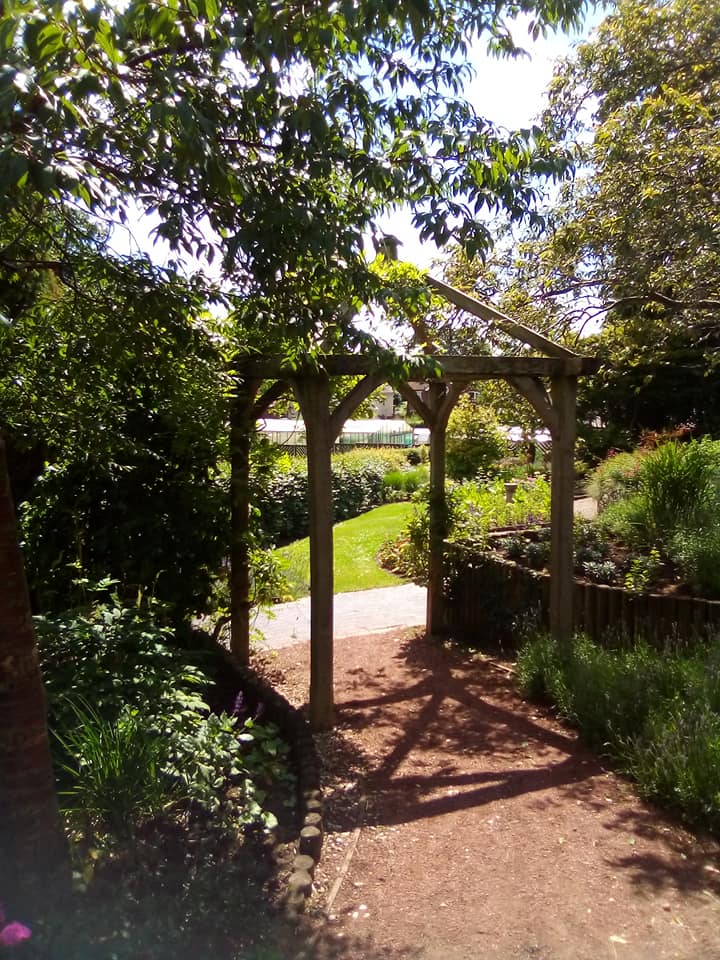 Wooden frame over footpath surrounded by mature trees