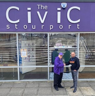 2 people shaking hands in front of glass fronted building with the civic stourport written on the front