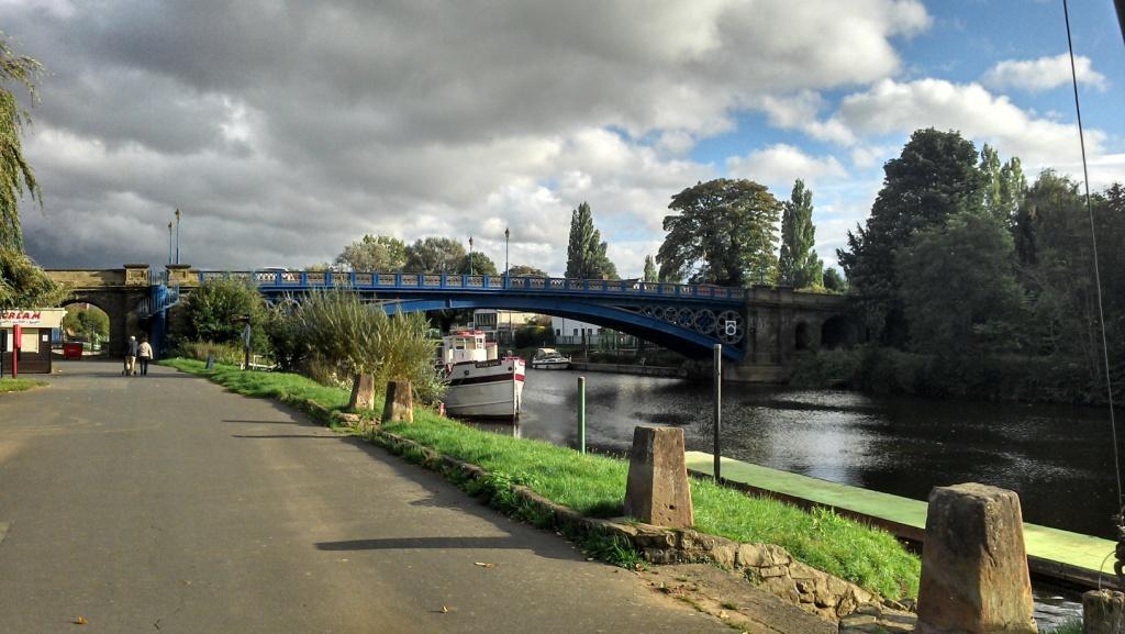 A footpath follows the winding River Severn through the Georgian town of Stourport-on-Severn, with a view of the river to the left and the river bridge in the distance.