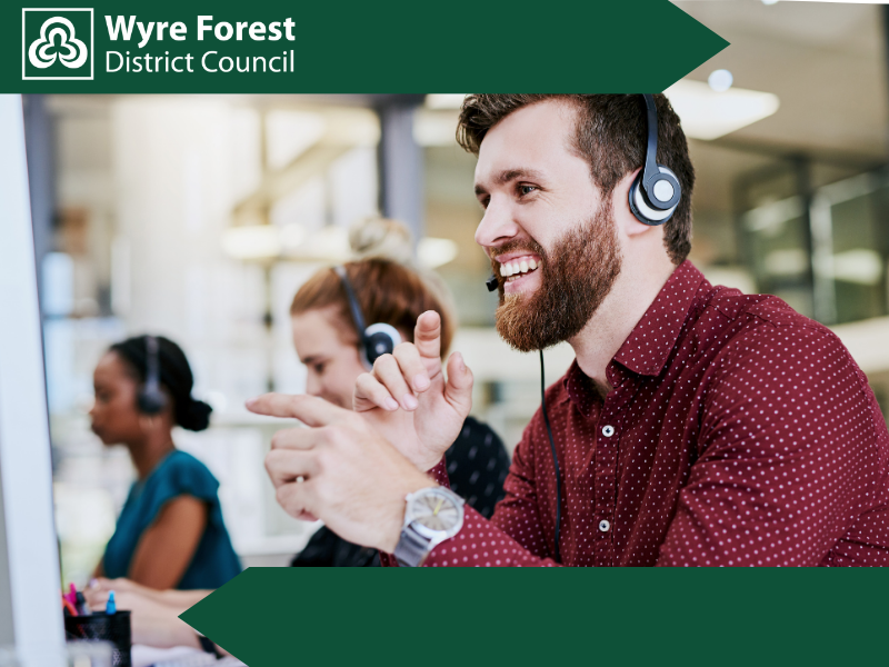 A man in a red shirt wearing a headset and smiling