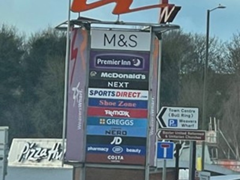 large retail park sign with multiple shop signs