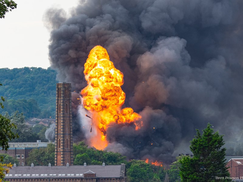 Fire ball explosion in town centre with dark black smoke filling the sky