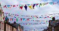 multi-coloured triangular bunting hanging across the street from house to house