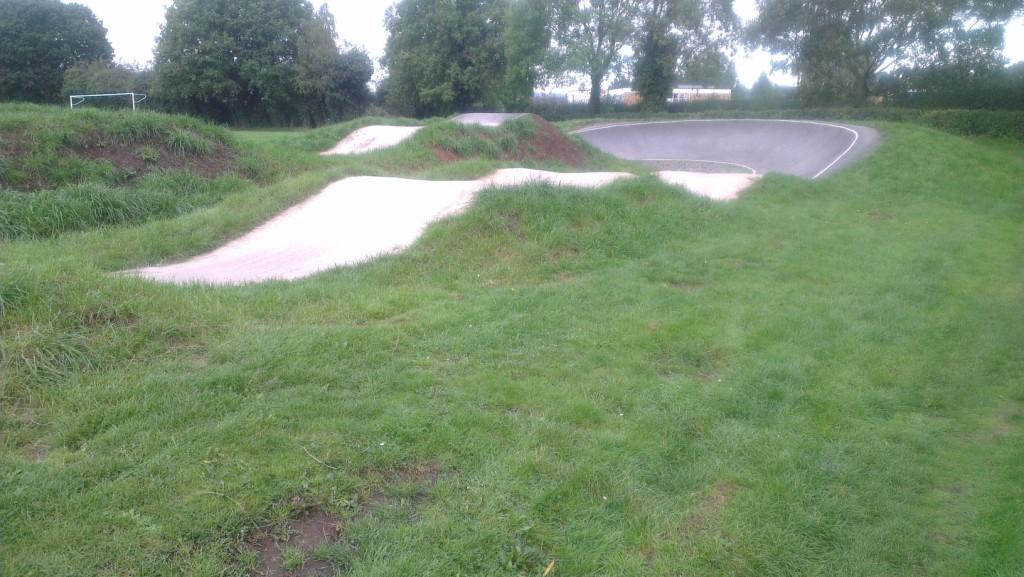 A grassed area surrounds the BMX track which has a course that contains a series of rolling jumps and turns.