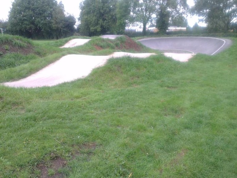A grassed area surrounds the BMX track which has a course that contains a series of rolling jumps and turns.