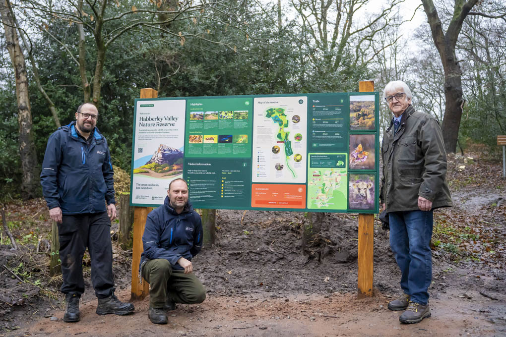 Three people stood next to a sign at Habberley Valley