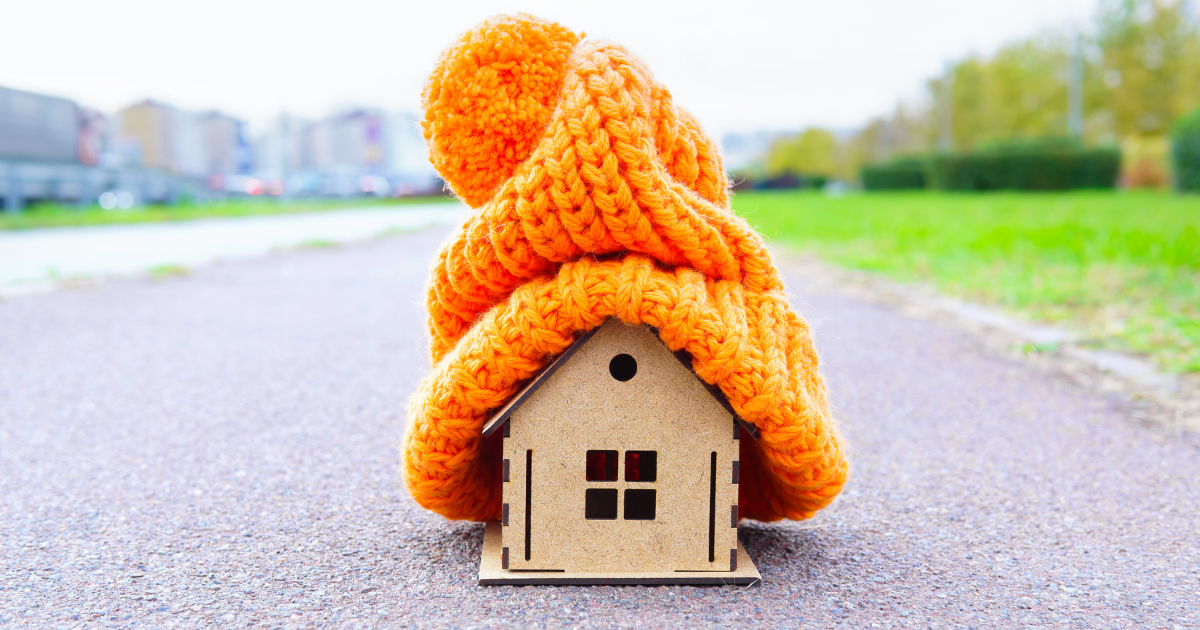 A small model house with an orange woolly hat on.