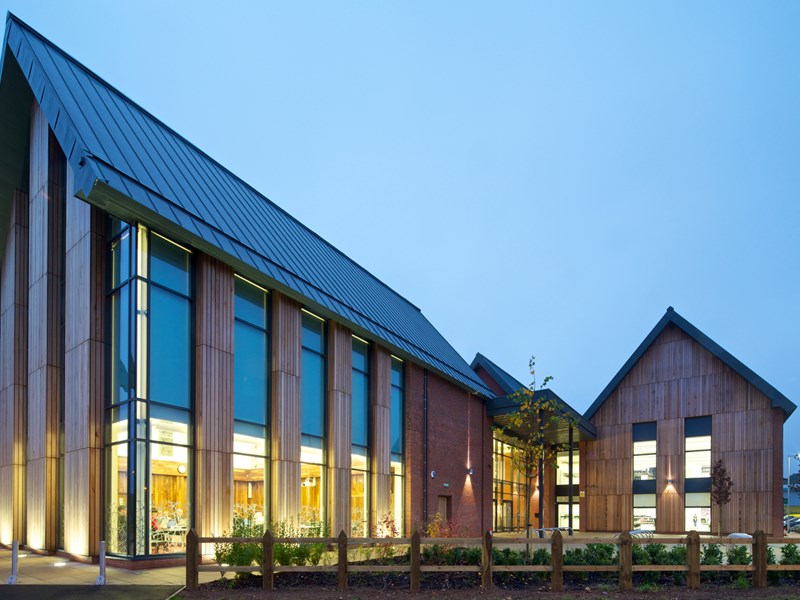 large wood and brick building at dusk