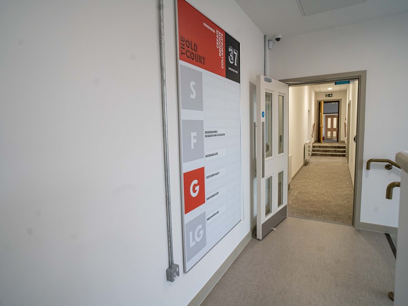 large sign showing offices on floor numbers inside building
