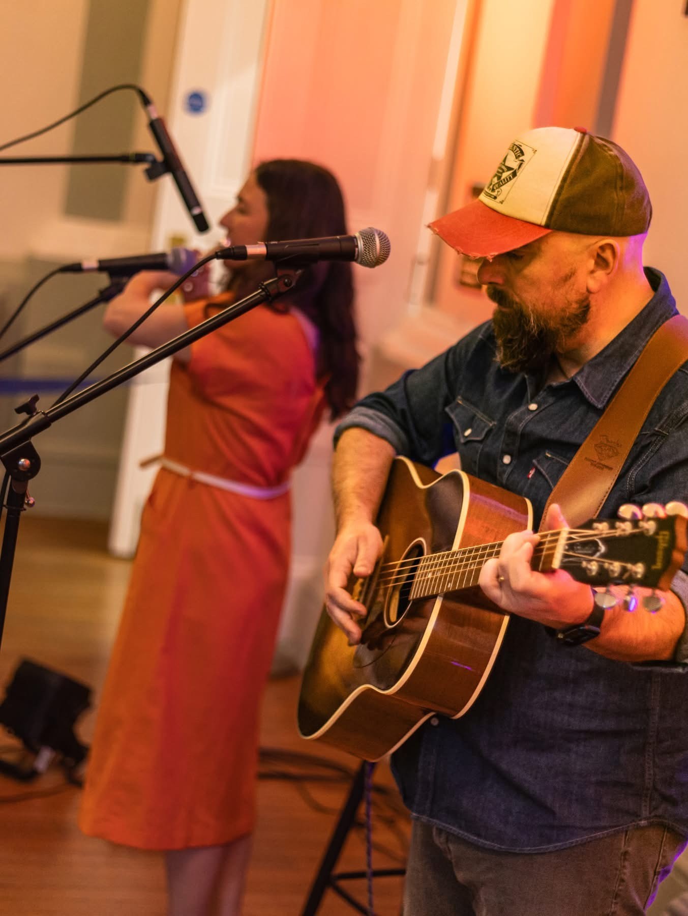 Photo of the 2  members of the acoustic duo Half a Crown. One is playing the guitar and is singing.
