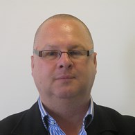 headshot of bald man wearing glasses