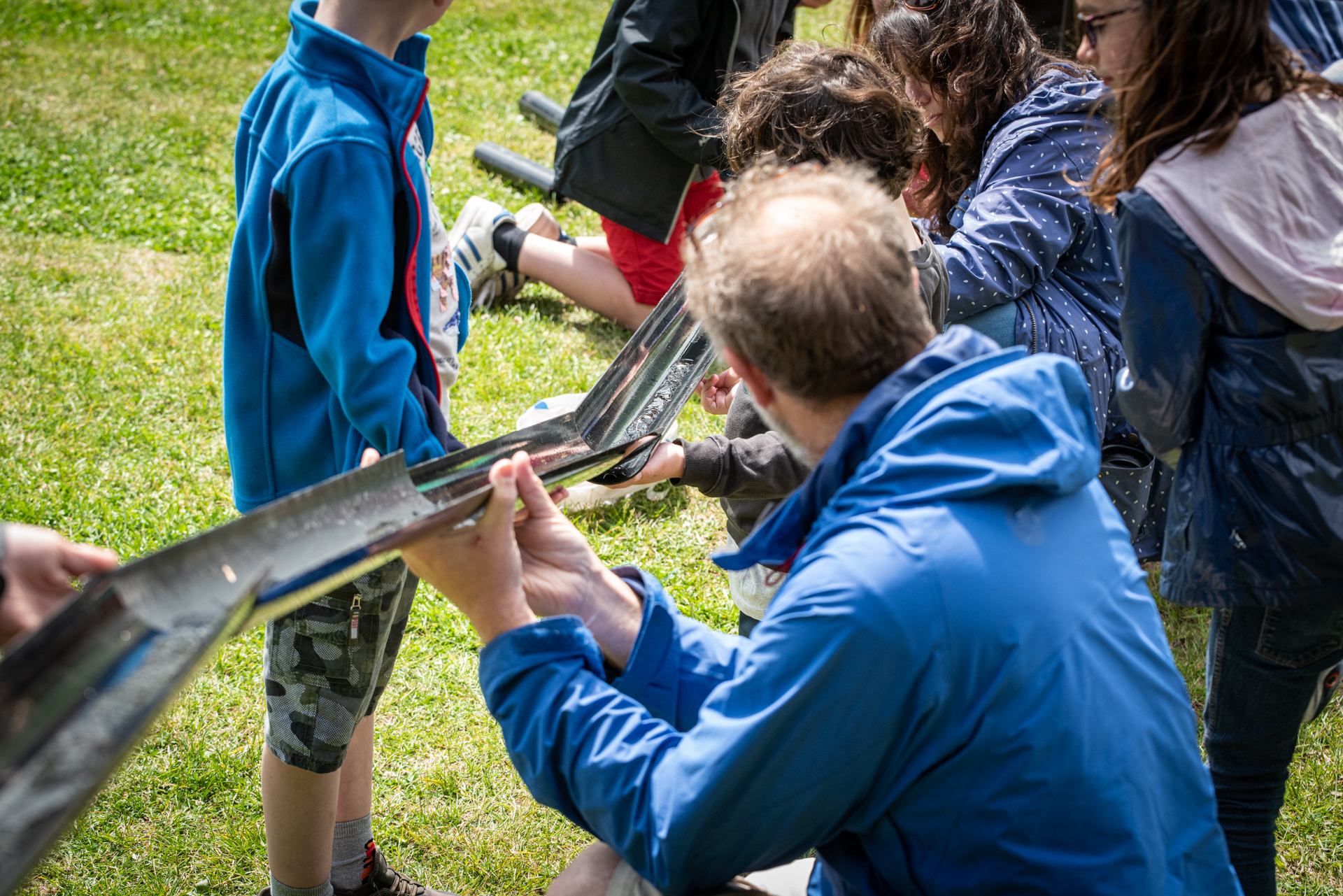 Group of adults and children working together in an outdoor workshop