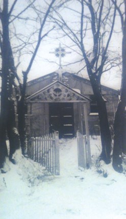 black and white image of church in between trees