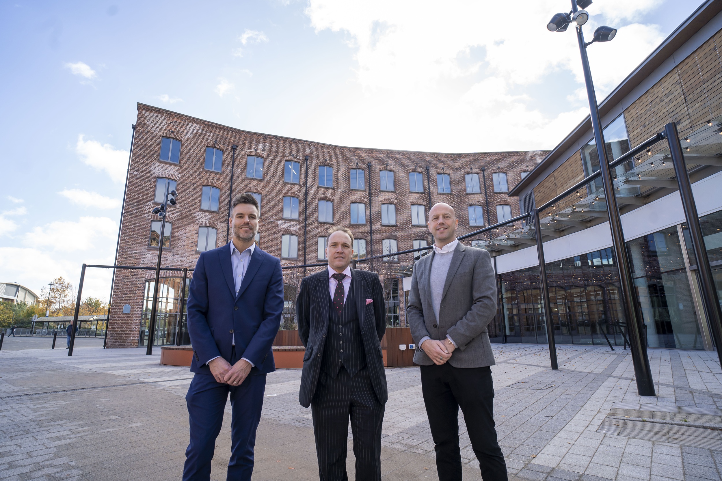Three people stood outside Piano Building