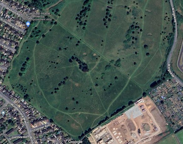 overhead photo of green area surrounded on 3 sides with housing