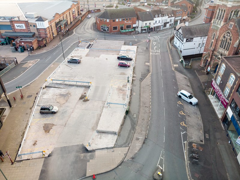 ariel view of car parked on large concrete foundation surrounded by roads