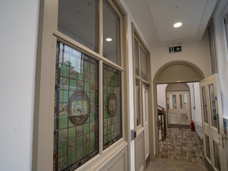 Stained glass windows along an internal corridor