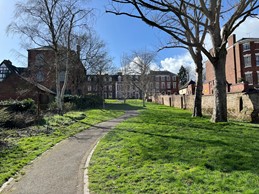 tree lined path through walled park