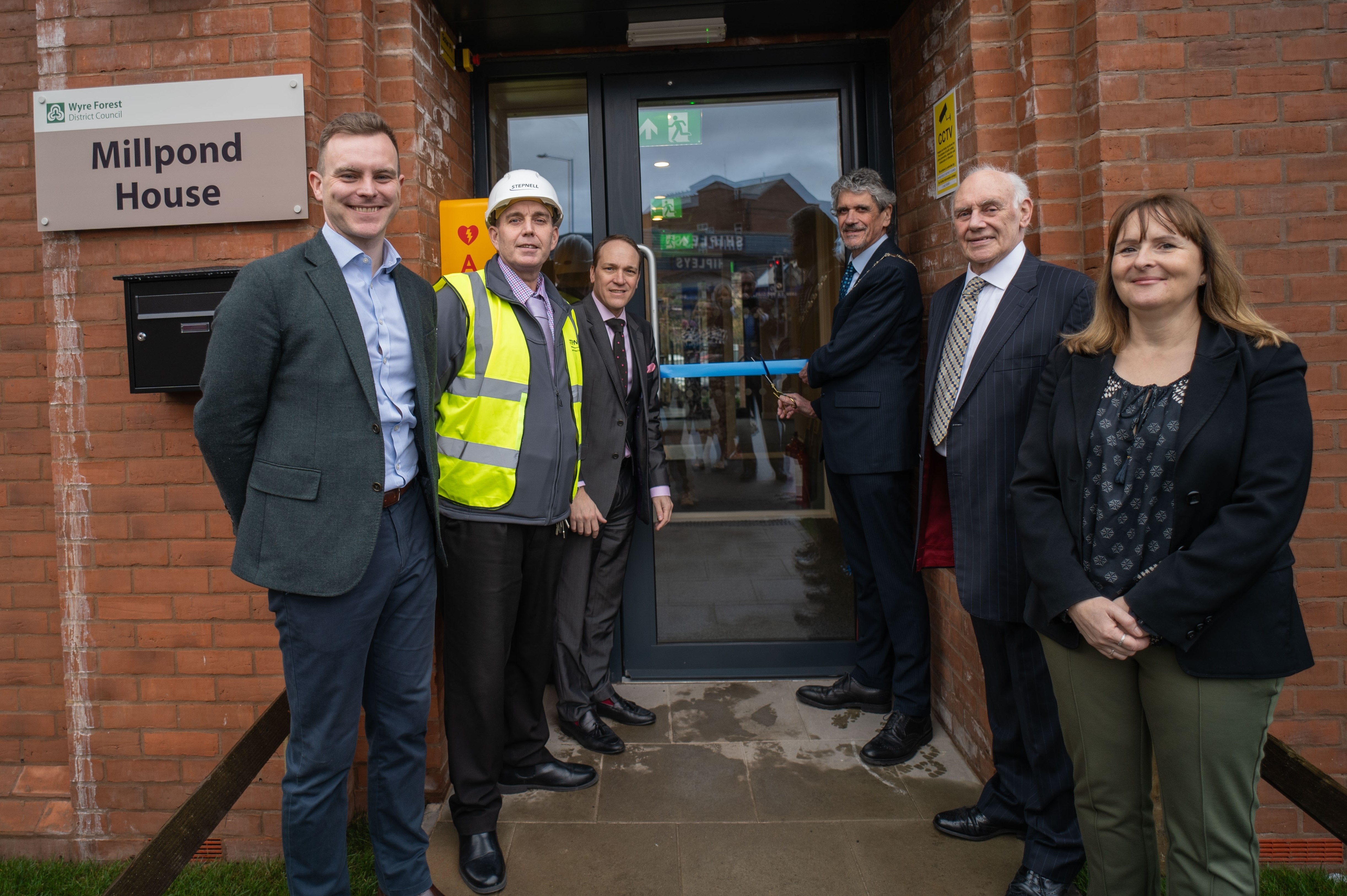 6 people in doorway for ribbon cutting ceremony