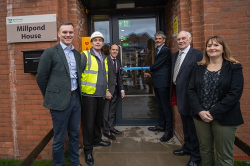 6 people in doorway for ribbon cutting ceremony