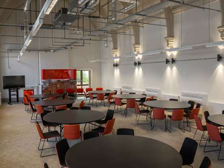 A large room with several round tables with chairs around them