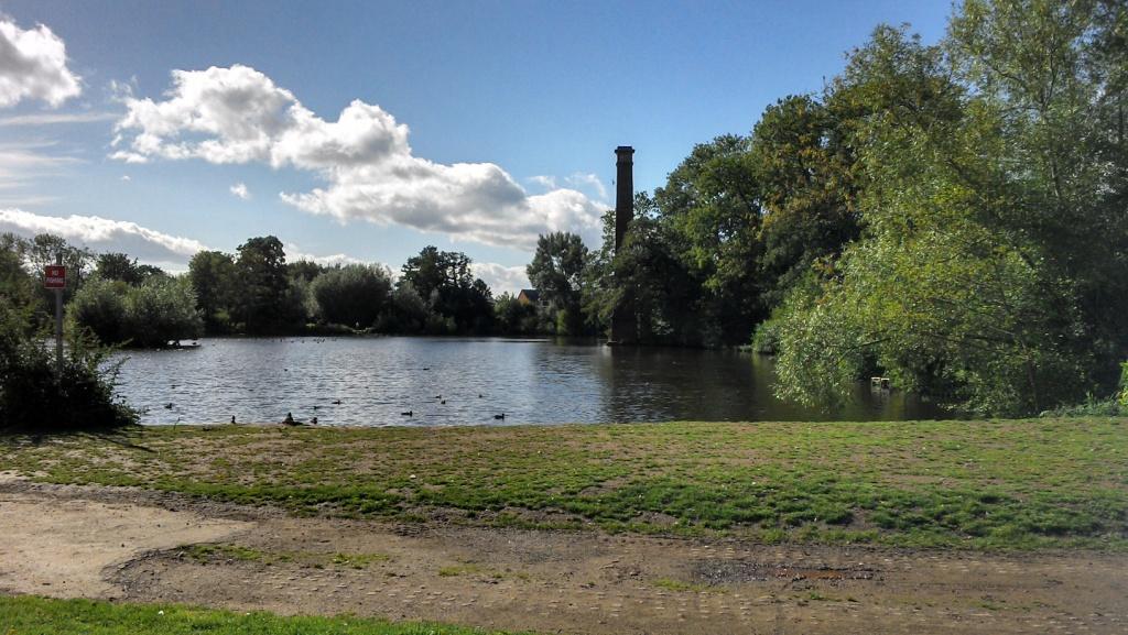 large chimney rises from middle of body of water