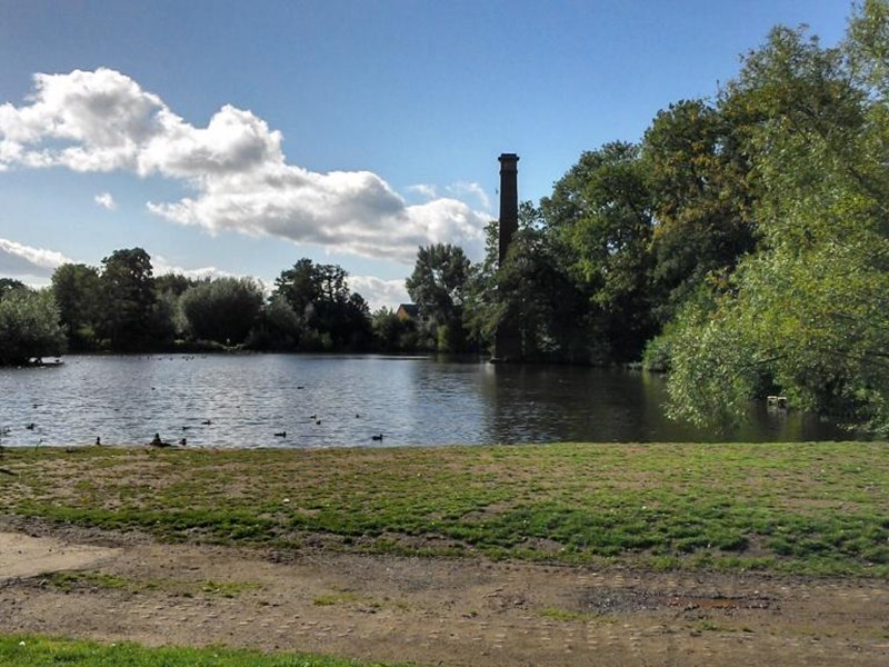 The stack pool centrally located in the public paark grassed area. The pool is bordered by mature trees over-hanging the pool water's edge. A mudded footpath has been worn into the grassed area around the pool edge.