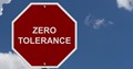 Sign which says zero tolerance with blue sky and clouds in background