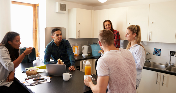 Five people sat around a table in a kitchen