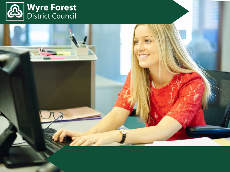A smiling woman using a desktop computer