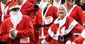 Group of men and women dressed in red santa outfits getting ready to race