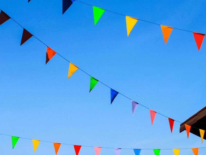 Coloured triangular bunting against a blue sky