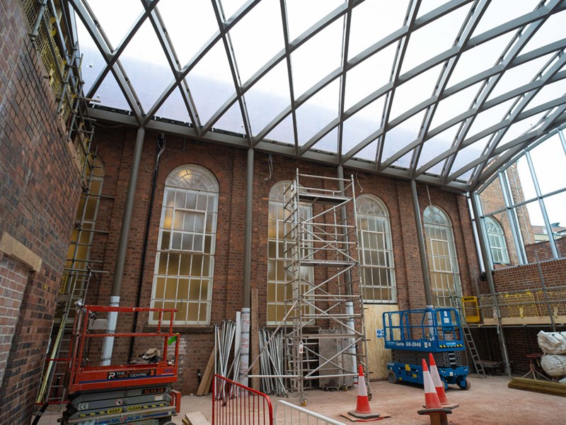 A wall with windows and a new glass ceiling above it